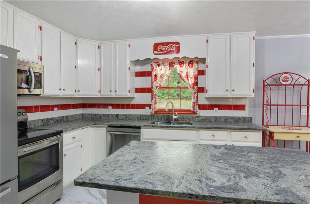 3243 Highway 184 Toccoa, GA 30577 - Photo 21 of 33 a kitchen with stainless steel appliances granite countertop a stove and a sink