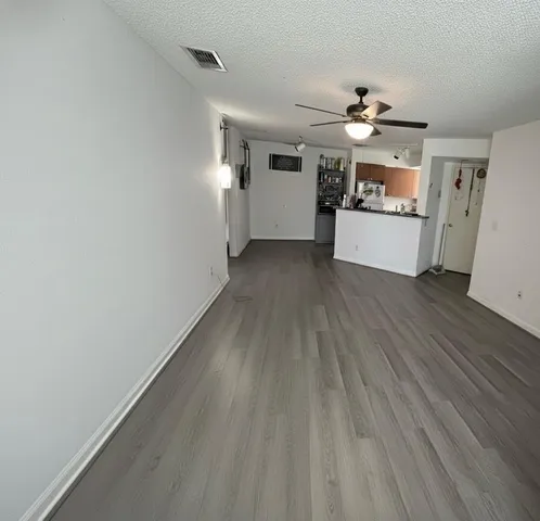 a view of a kitchen with wooden floor and electronic appliances