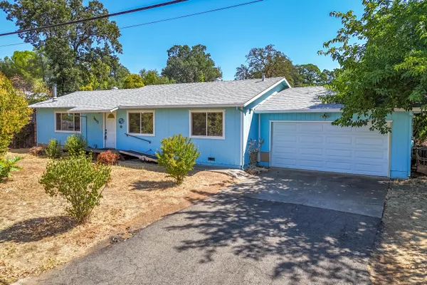 a front view of house with yard and trees around