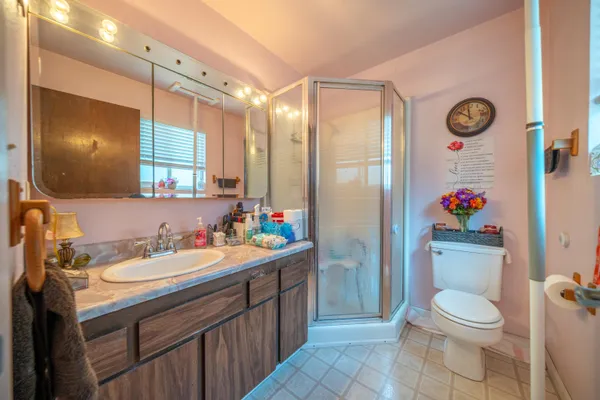 a bathroom with a sink a toilet and shower