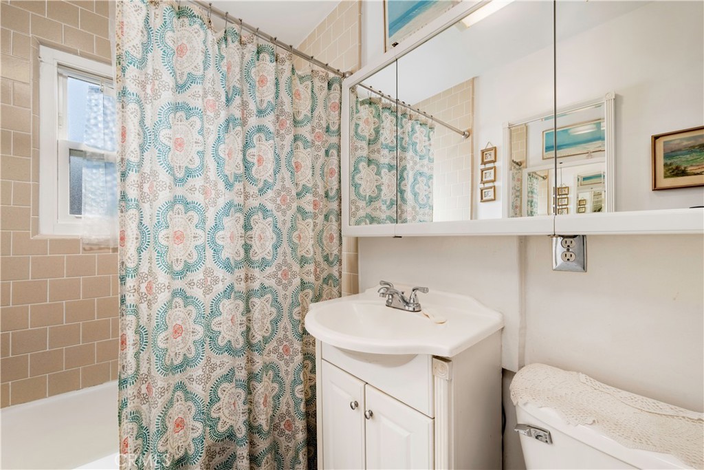 5016 Falcon Avenue Long Beach, CA 90807 - Photo 13 of 23 a bathroom with a sink a toilet and shower curtain