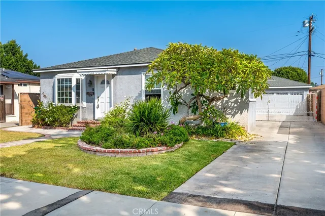 a front view of a house with a yard and potted plants