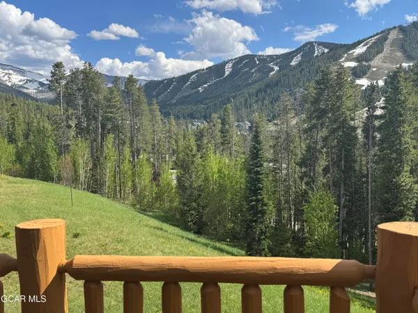 a view of a green yard with a house in the background