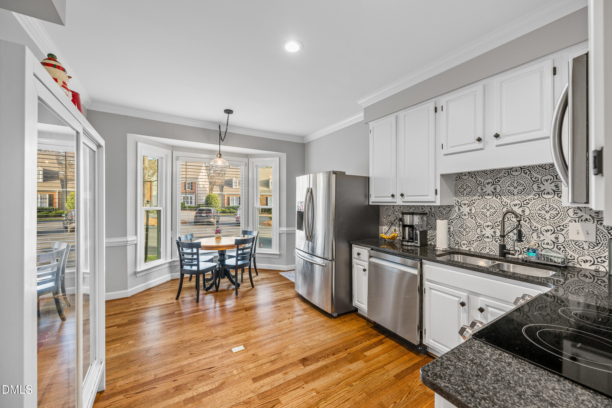6011 Tenter Banks Square Raleigh, NC 27609 - Photo 10 of 37 a kitchen with stainless steel appliances granite countertop a stove refrigerator and a dining table with wooden floor