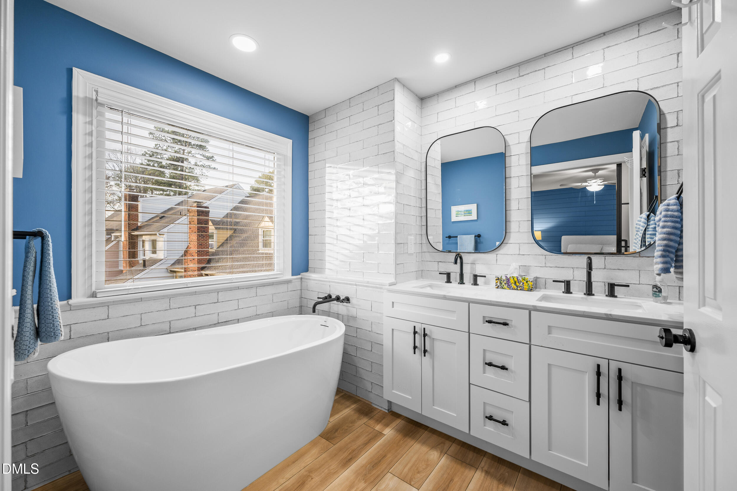 6011 Tenter Banks Square Raleigh, NC 27609 - Photo 25 of 37 a spacious bathroom with a double vanity sink a large mirror a bathtub and window