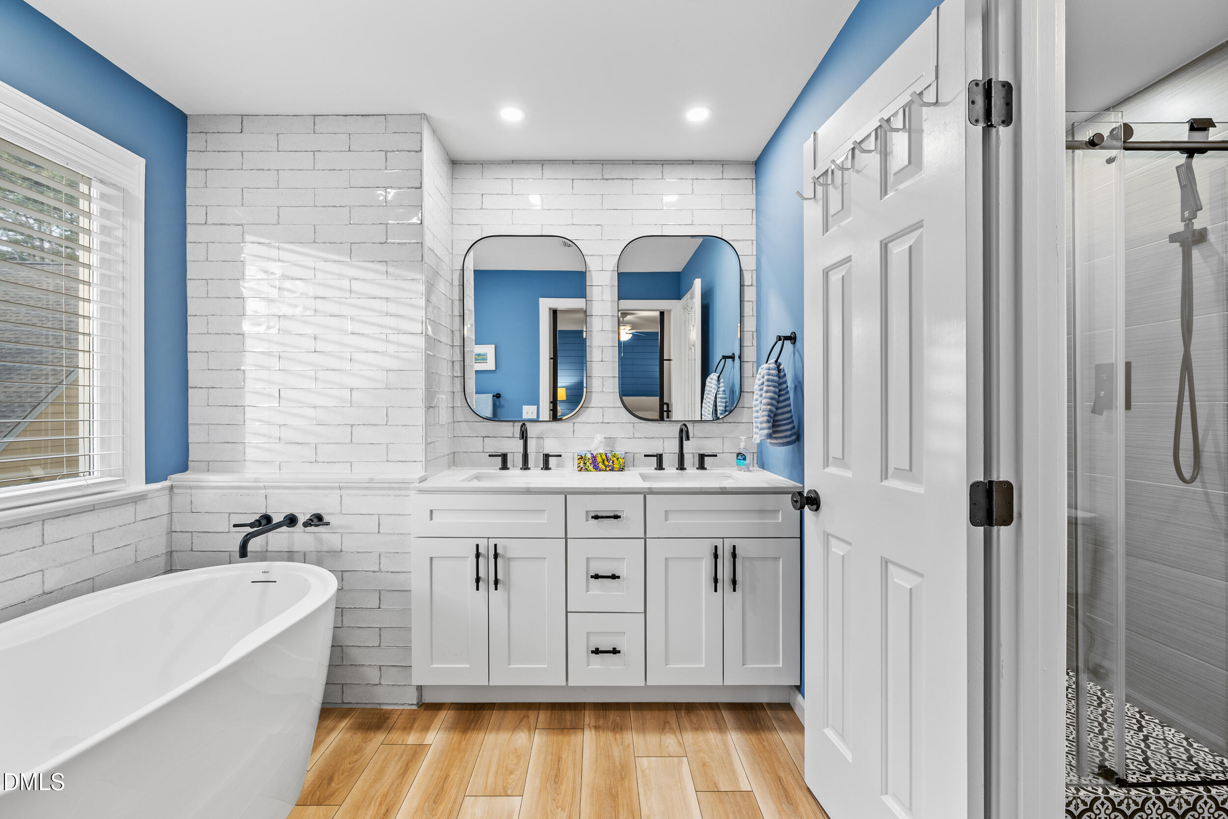 6011 Tenter Banks Square Raleigh, NC 27609 - Photo 26 of 37 a spacious bathroom with a double vanity sink a mirror a bathtub and next to a window