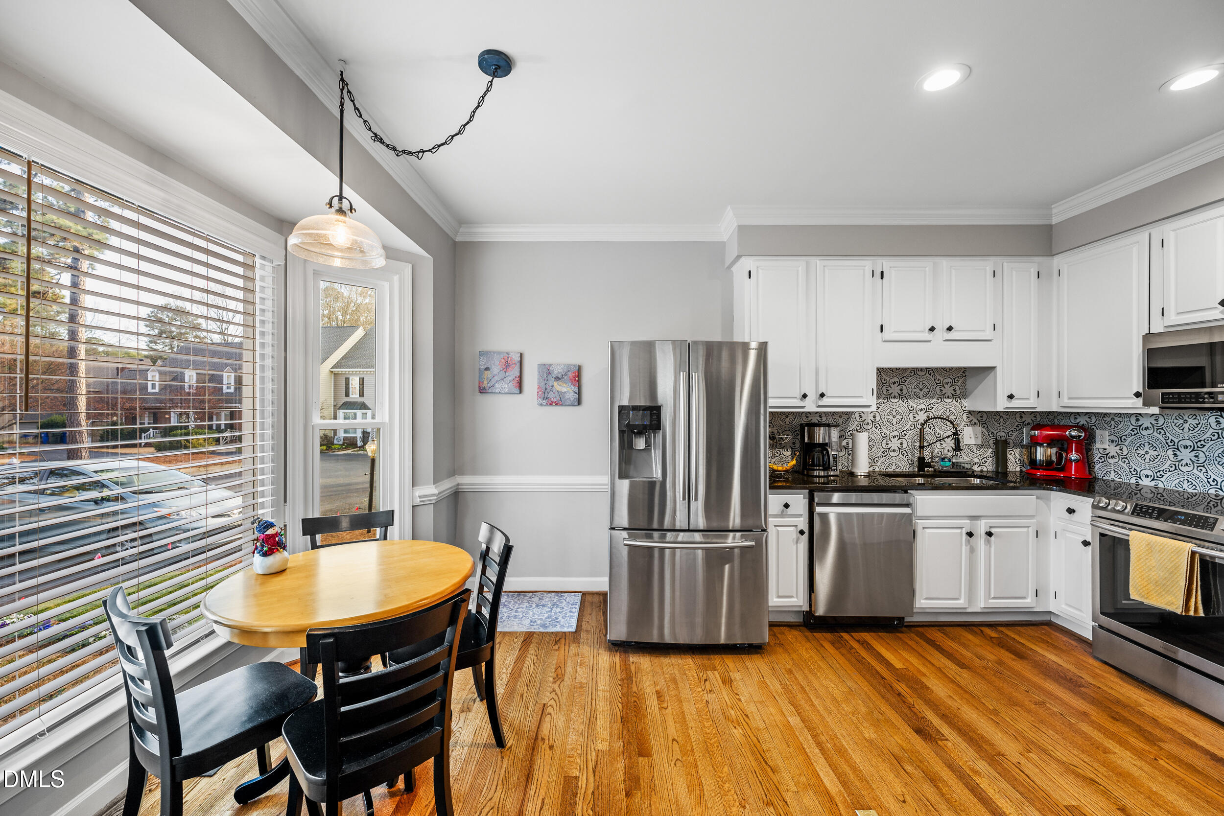 6011 Tenter Banks Square Raleigh, NC 27609 - Photo 7 of 37 a kitchen with granite countertop a refrigerator a stove a sink dishwasher a dining table and chairs with wooden floor