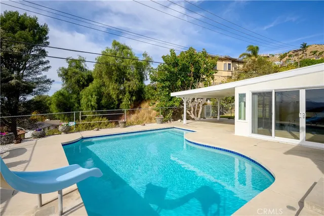 a view of a house with pool and chairs