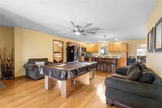 a living room with furniture kitchen view and a large window