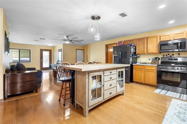 a kitchen with stainless steel appliances a sink a stove top oven a counter space and cabinets