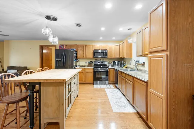 a large kitchen with kitchen island a large island in it