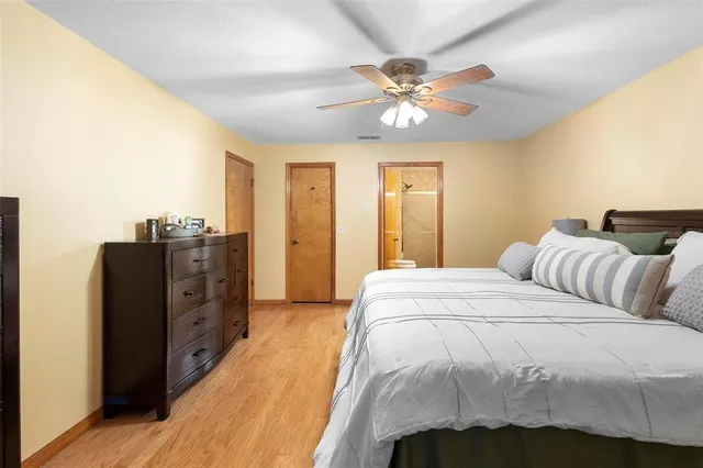 a spacious bedroom with a bed and cabinet