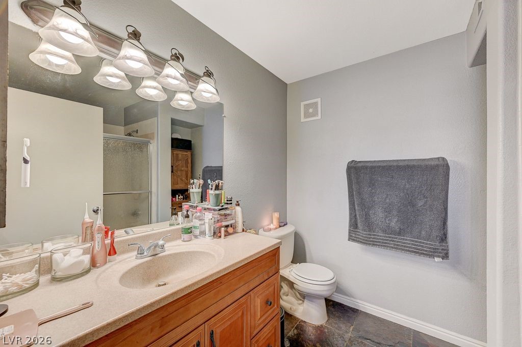 7885 West Flamingo Road, Unit 1079 Las Vegas, NV 89147 - Photo 19 of 35 This clean bathroom offers a vanity, a toilet, and a glass-enclosed shower.