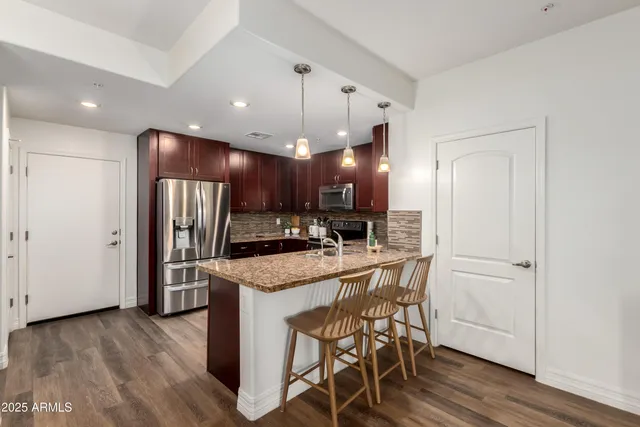 a kitchen with a center island wooden cabinets and stainless steel appliances