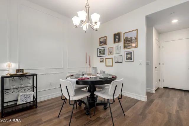 a view of a dining room with furniture a chandelier and wooden floor
