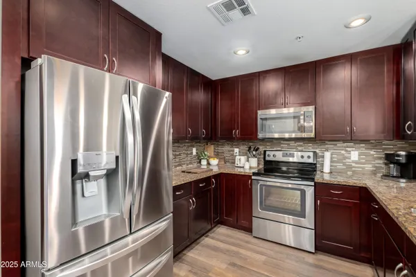 a kitchen with stainless steel appliances granite countertop a refrigerator stove and sink