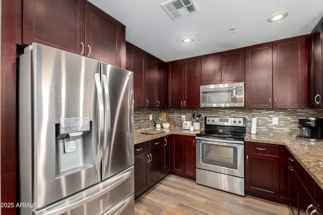 a kitchen with stainless steel appliances granite countertop a refrigerator stove and sink