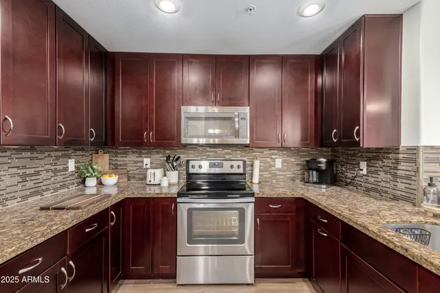 a kitchen with kitchen island granite countertop a sink cabinets and wooden floor