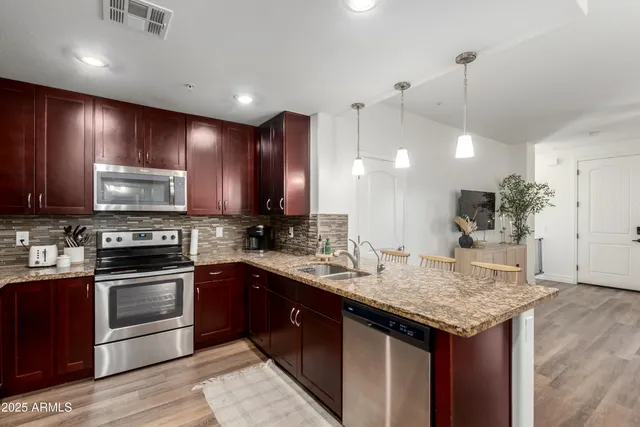 a kitchen with granite countertop wooden cabinets and white appliances