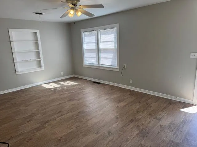 wooden floor in an empty room with a window