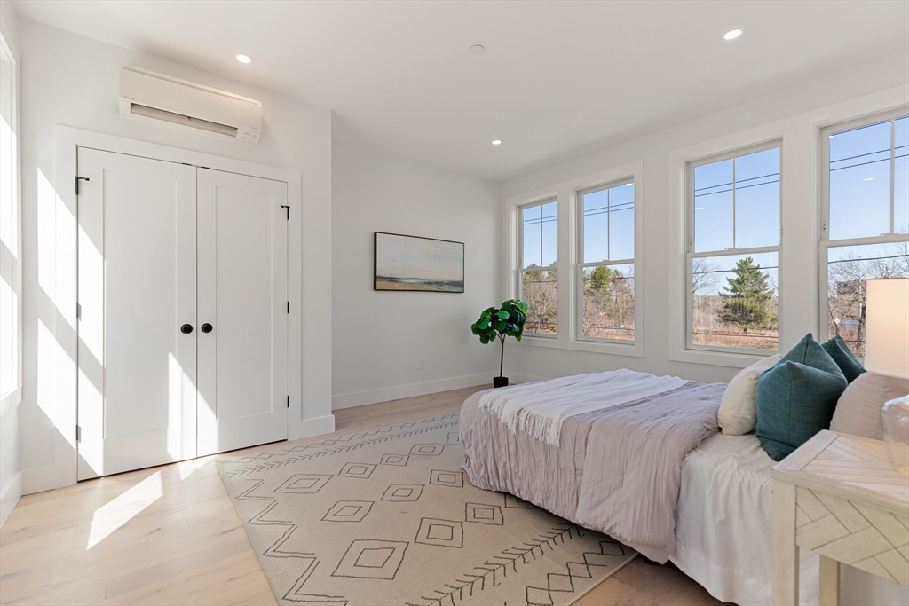 656 Mystic Avenue, Unit B Somerville, MA 02145 - Photo 15 of 40 a bedroom with a bed a window and potted plant