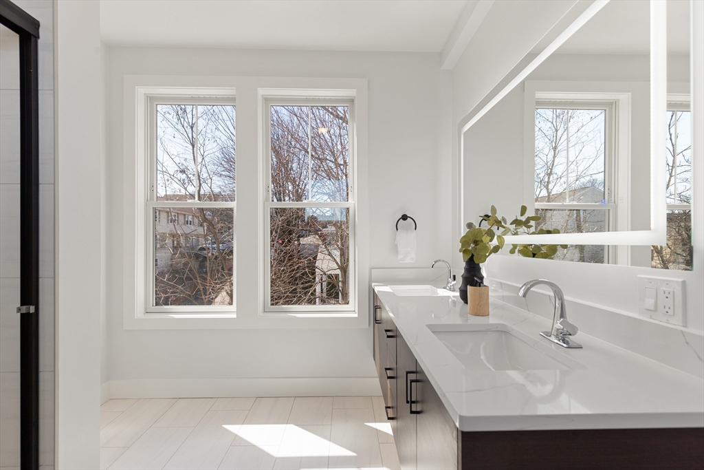 656 Mystic Avenue, Unit B Somerville, MA 02145 - Photo 27 of 40 a bathroom with a sink and a large mirror