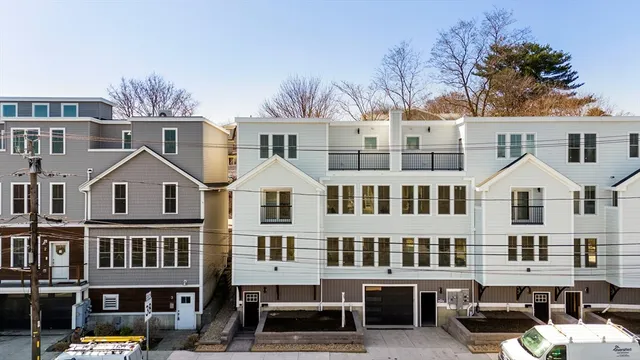 an aerial view of residential houses with cars parked