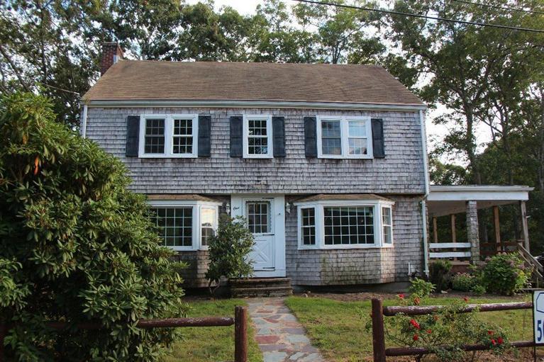 1 Cross Road Bourne, MA 02532 - Photo 2 of 22 a front view of a house with a yard and potted plants