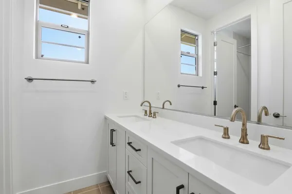 a bathroom with a double vanity sink and mirror