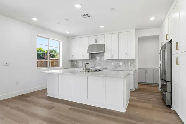 a kitchen with stainless steel appliances granite countertop a sink stove and refrigerator