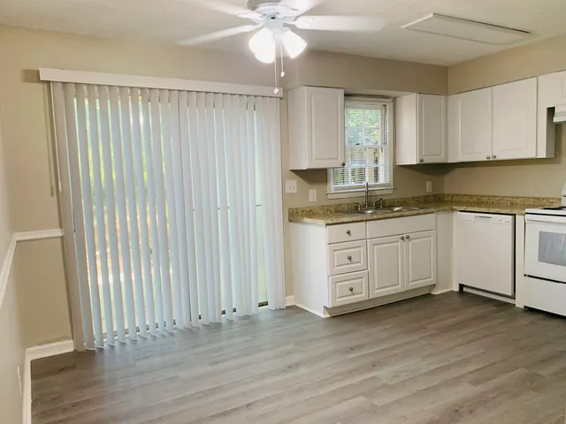 a kitchen with a sink cabinets and wooden floor