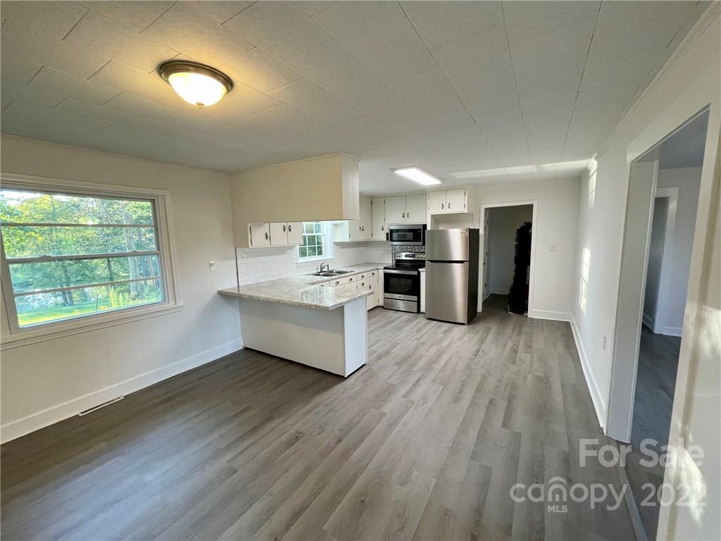 3180 Foster Road Cleveland, NC 27013 - Photo 2 of 16 a large kitchen with a wooden floor and a window