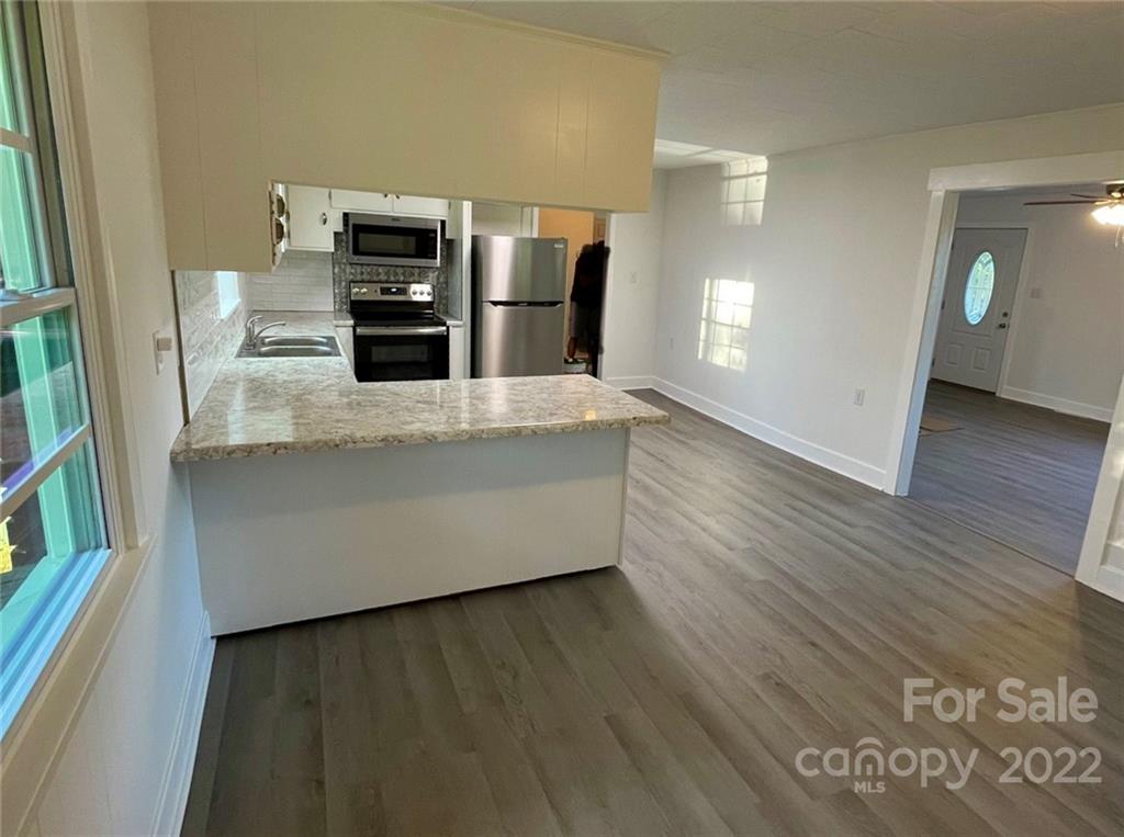3180 Foster Road Cleveland, NC 27013 - Photo 4 of 16 a living room with stainless steel appliances wooden floor and a fireplace
