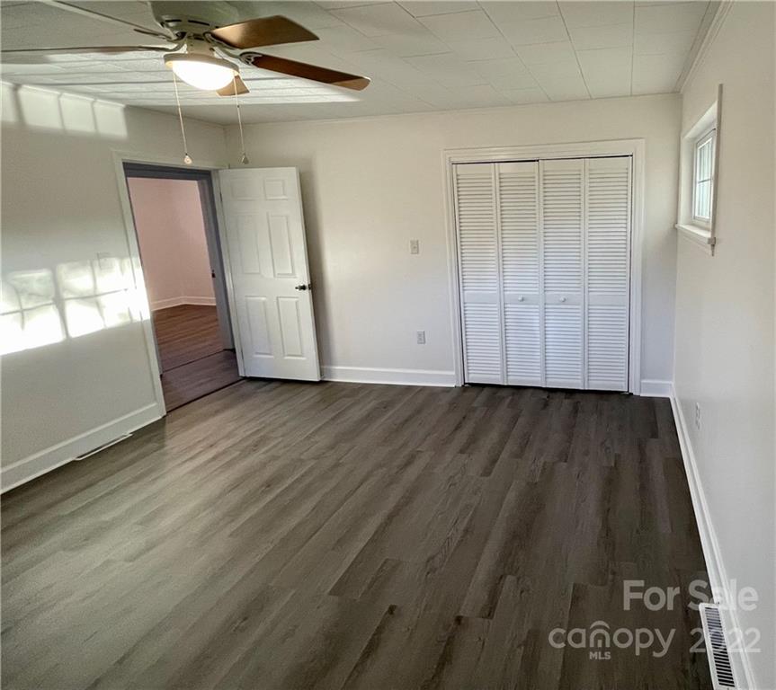 3180 Foster Road Cleveland, NC 27013 - Photo 9 of 16 an empty room with wooden floor cabinet and windows