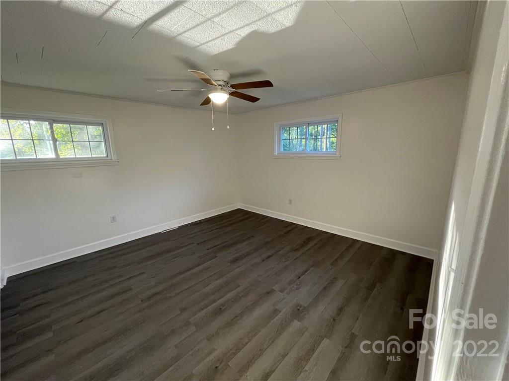 3180 Foster Road Cleveland, NC 27013 - Photo 10 of 16 an empty room with wooden floor cabinet and windows
