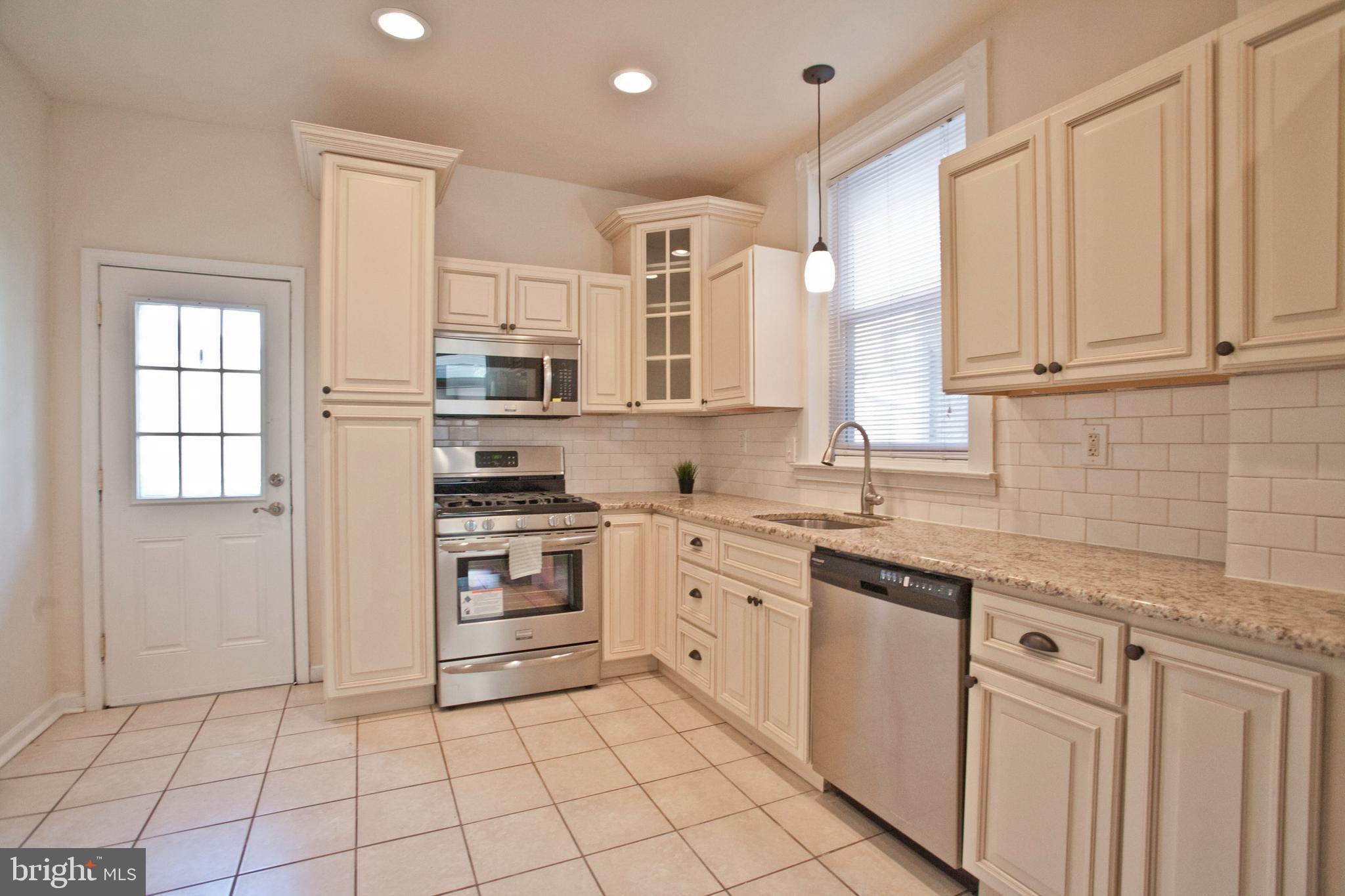 4205 Terrace Street Philadelphia, PA 19128 - Photo 9 of 30 a kitchen with granite countertop white cabinets stainless steel appliances a sink and a window