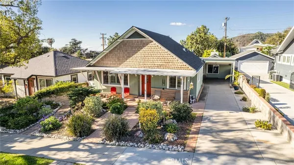 a front view of a house with a yard and potted plants