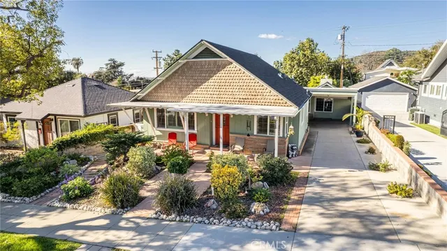a front view of a house with a yard and potted plants