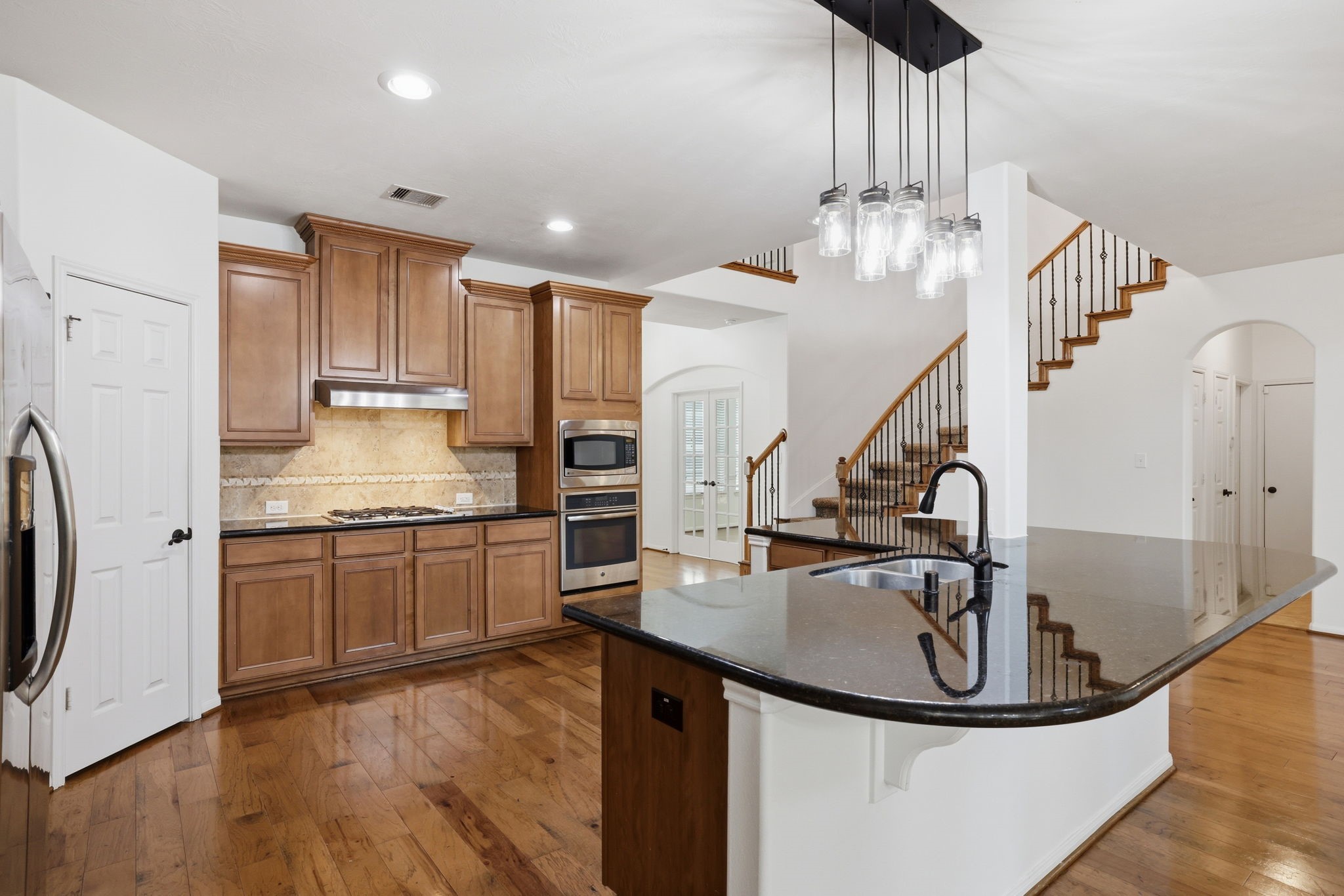 8169 Tranquil Lake Way Conroe, TX 77385 - Photo 8 of 26 a kitchen with stainless steel appliances granite countertop a sink a stove and a refrigerator