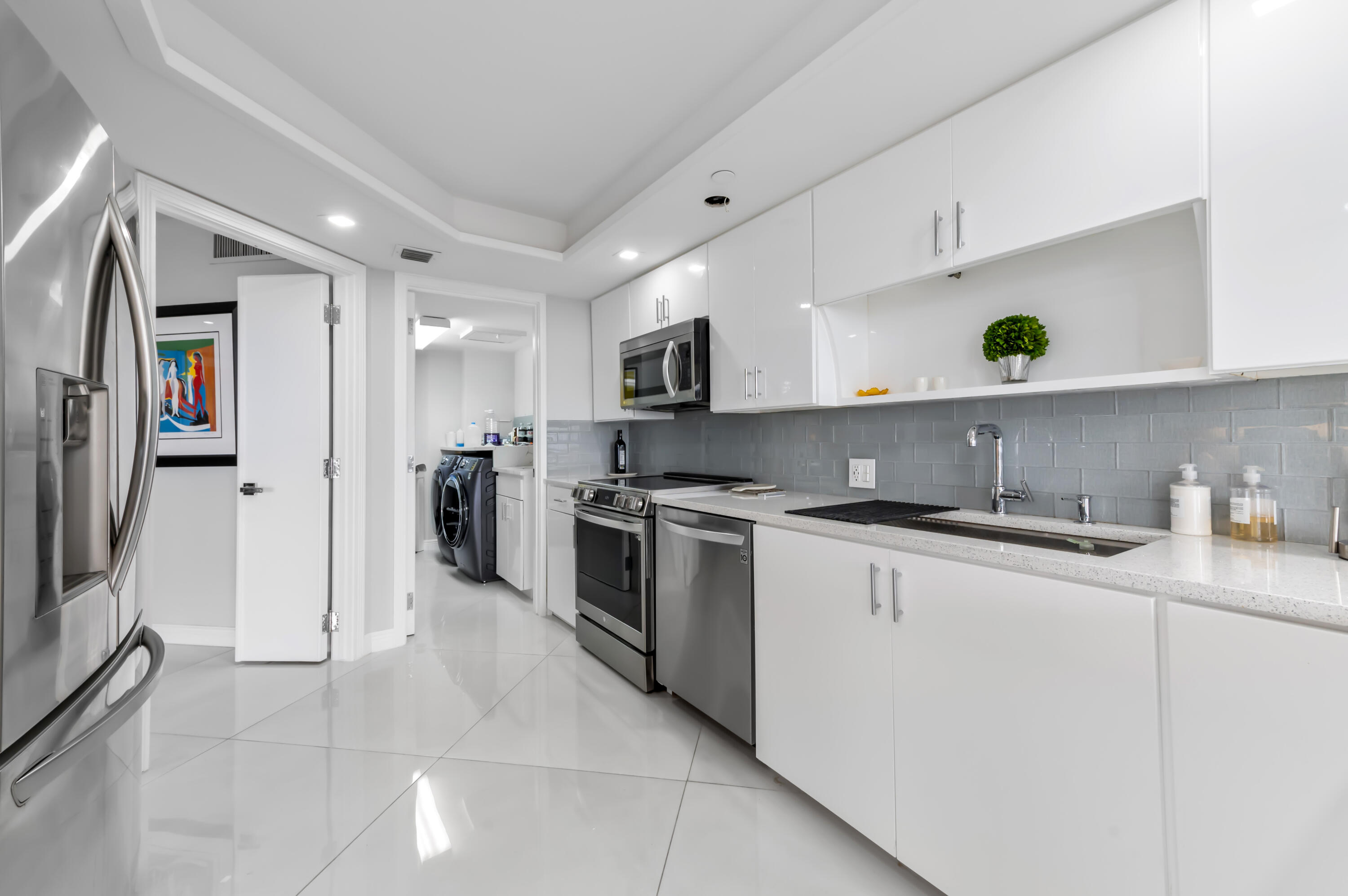 1900 Consulate Place, Unit 2104 West Palm Beach, FL 33401 - Photo 16 of 72 a kitchen with stainless steel appliances granite countertop a sink and a refrigerator