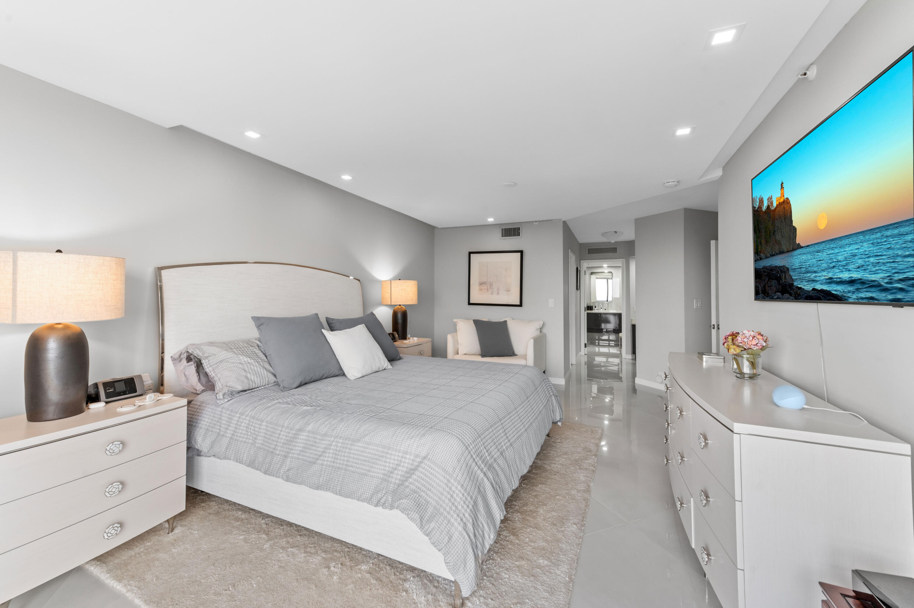 1900 Consulate Place, Unit 2104 West Palm Beach, FL 33401 - Photo 20 of 72 a spacious bedroom with a bed and a flat screen tv