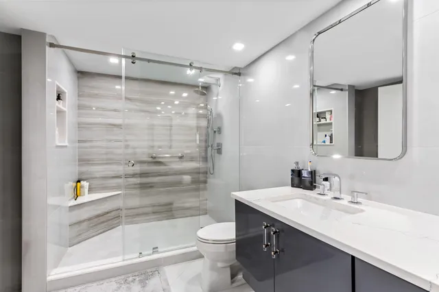 a bedroom with a bed a couch and a flat screen tv