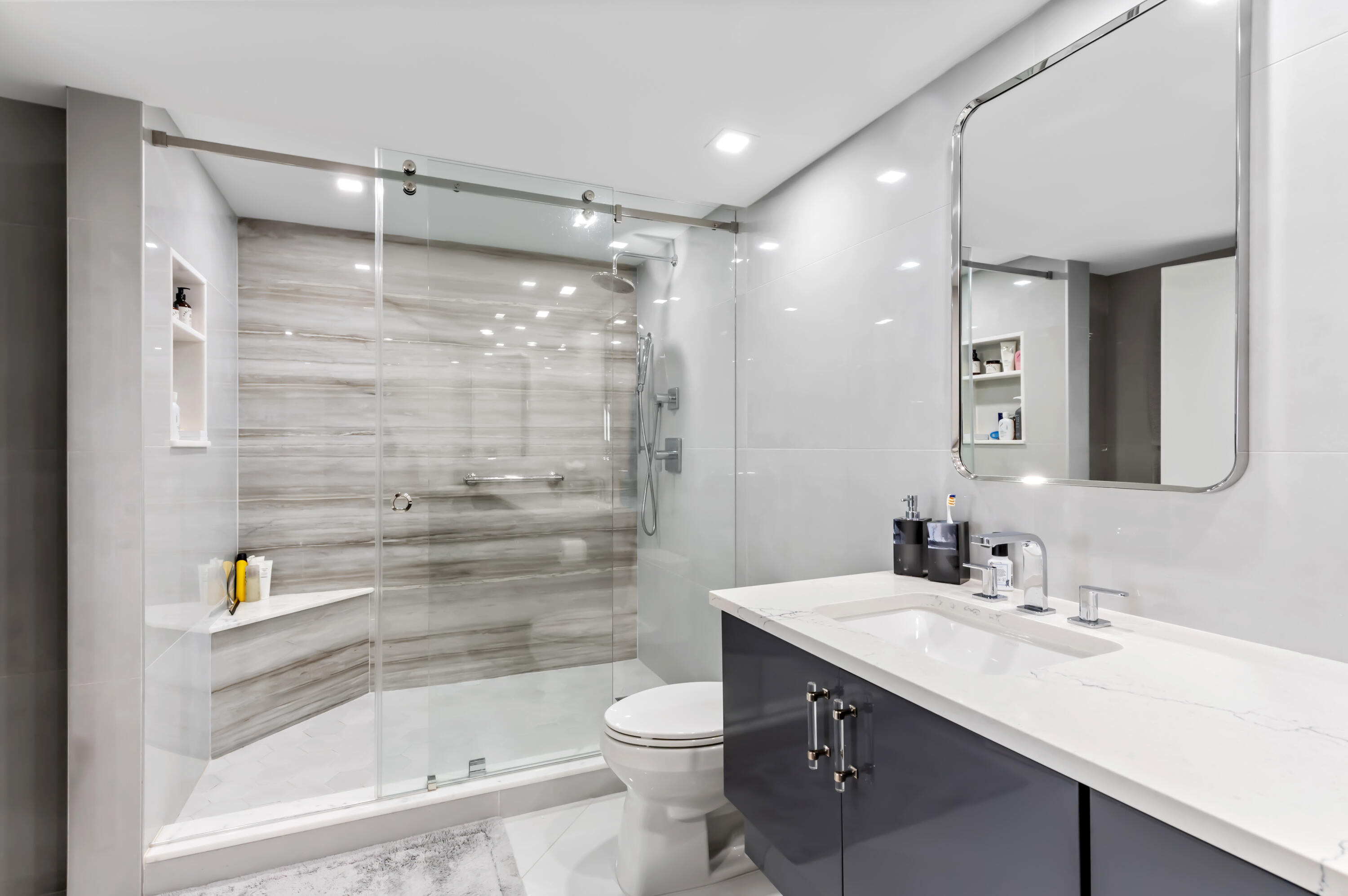 1900 Consulate Place, Unit 2104 West Palm Beach, FL 33401 - Photo 24 of 72 a bathroom with a granite countertop sink toilet and shower