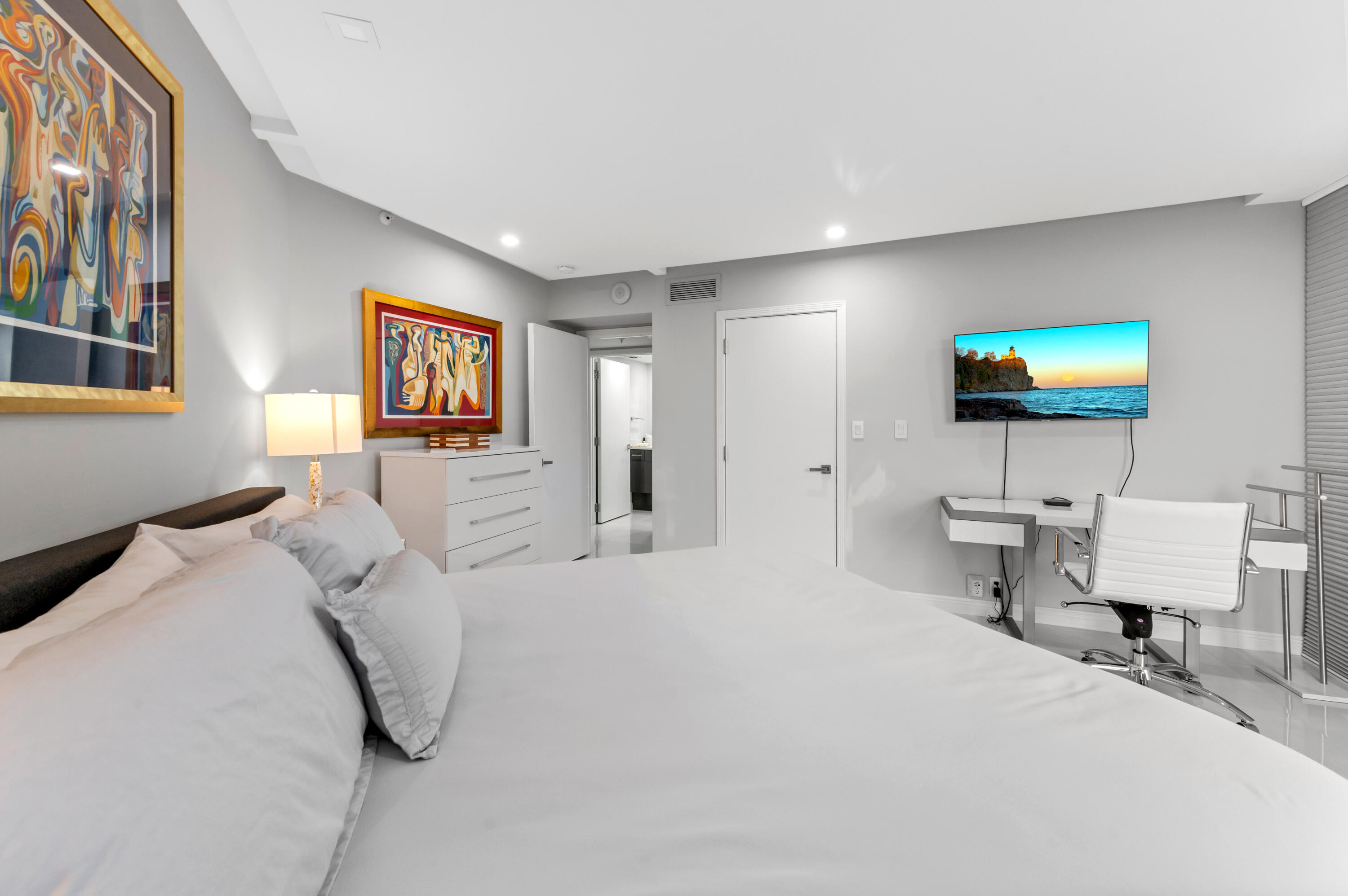 1900 Consulate Place, Unit 2104 West Palm Beach, FL 33401 - Photo 28 of 72 a bedroom with a bed a couch and a flat screen tv