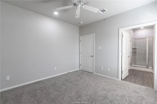 an empty room with fan and entrance