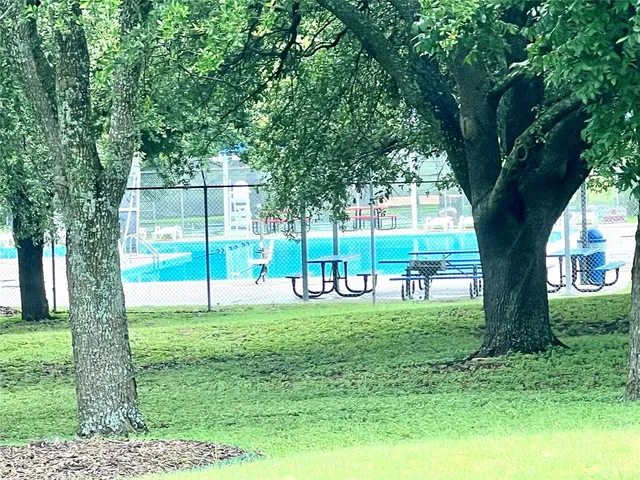 a sign board with a play ground in the back yard