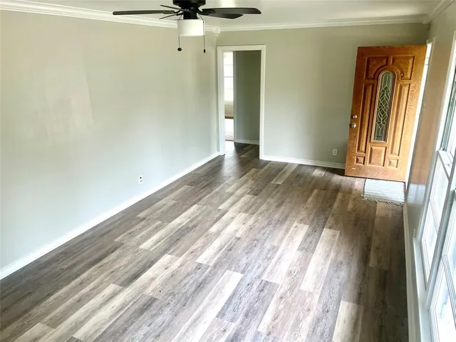 a view of a room with wooden floor and a window