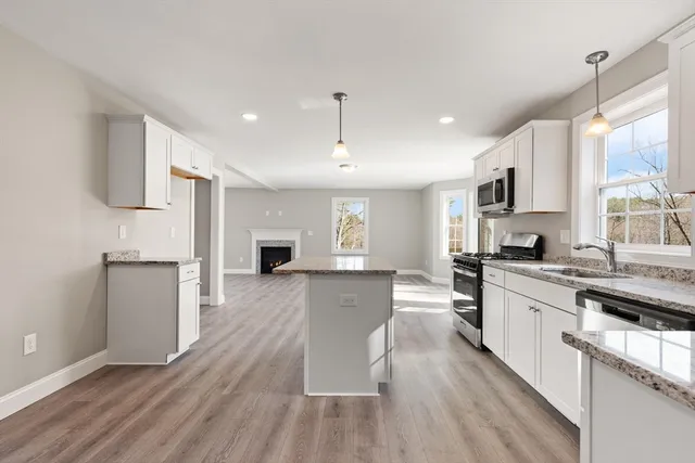 a large kitchen with cabinets wooden floor and stainless steel appliances