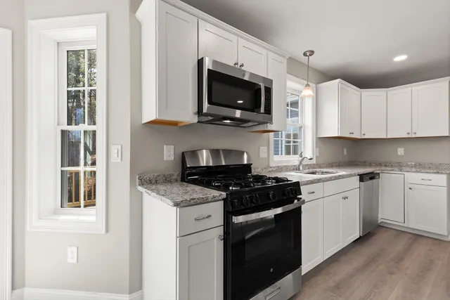 a kitchen with granite countertop a sink and a stove top oven