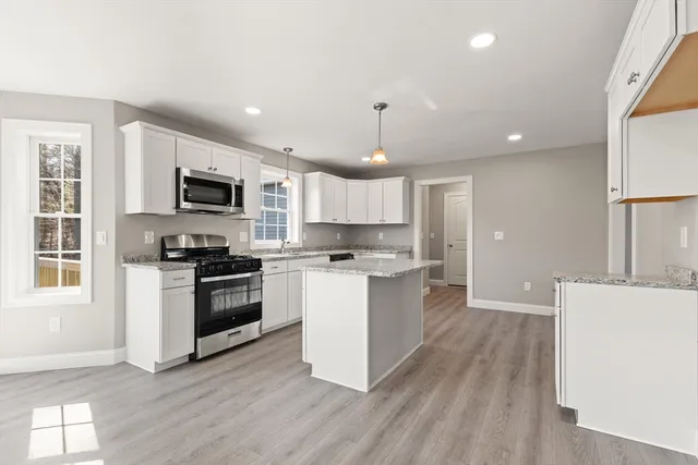 a kitchen with a sink wooden floor and stainless steel appliances